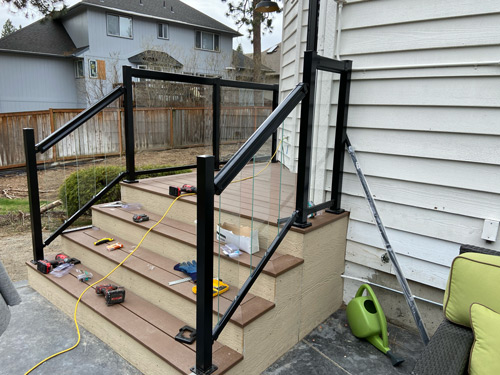 A picture of a new small composite deck and glass railing.